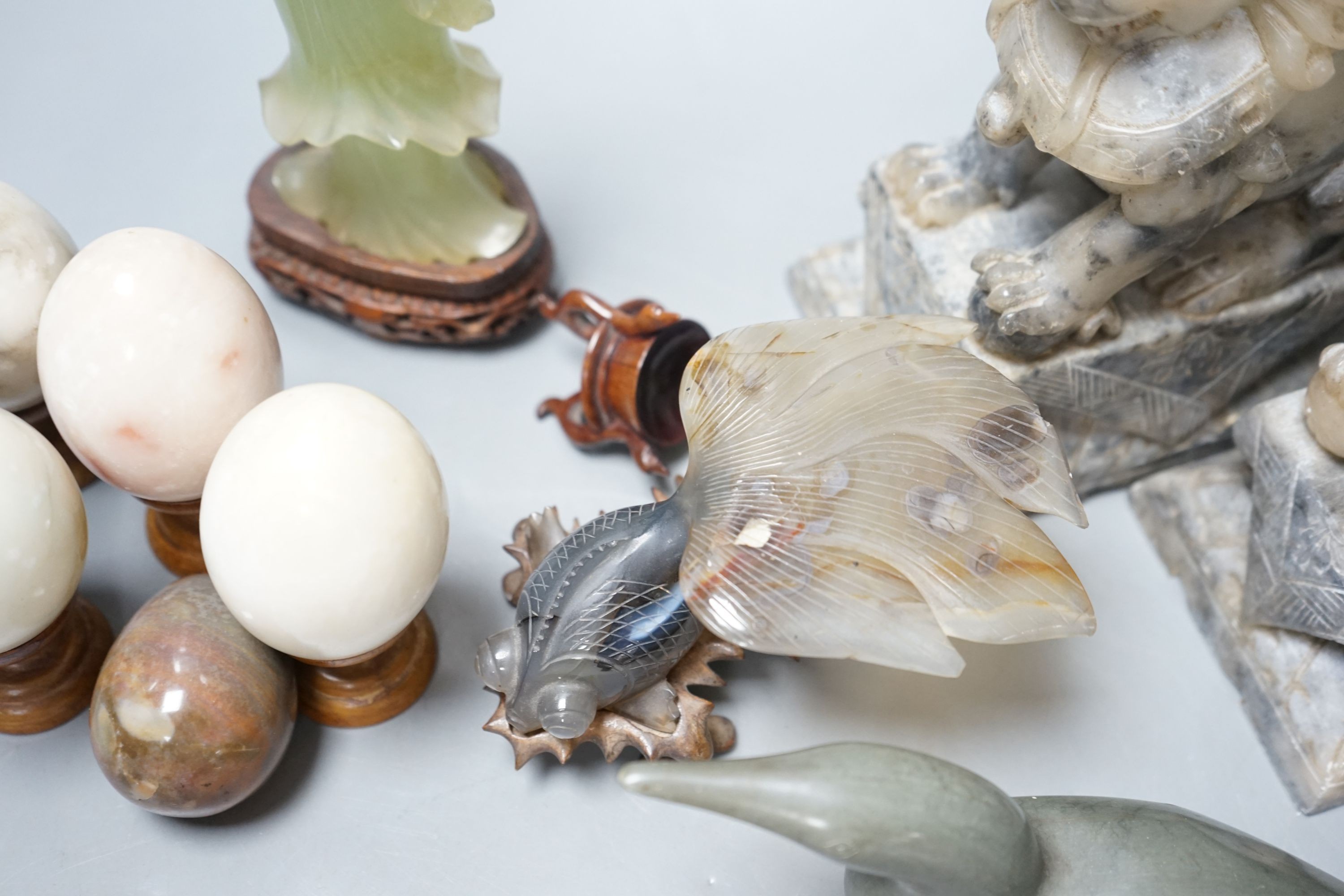 A pair of Chinese soapstone stone carvings of Buddhist lions, 18cm, two Chinese hardstone carvings, an Inuit carving and five hardstone eggs